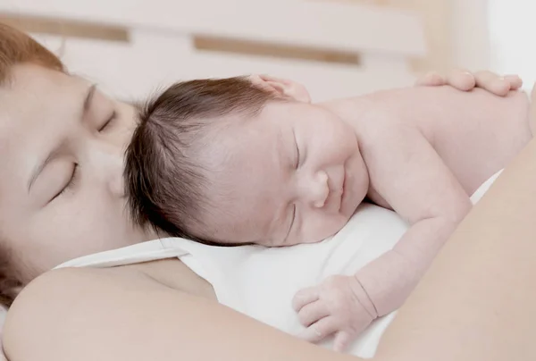 Счастливая мать и ее новорожденный ребенок целуются и обнимаются — стоковое фото