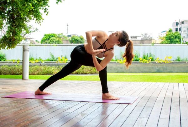 Unga kvinnor gör yoga posera på park — Stockfoto