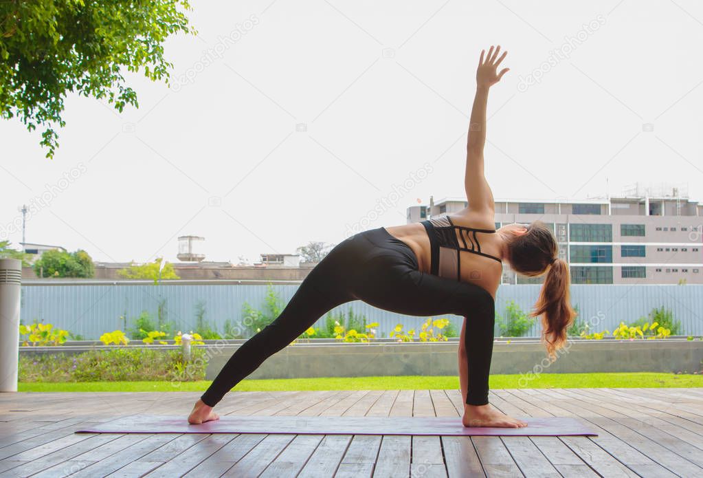 young women doing yoga pose at the park