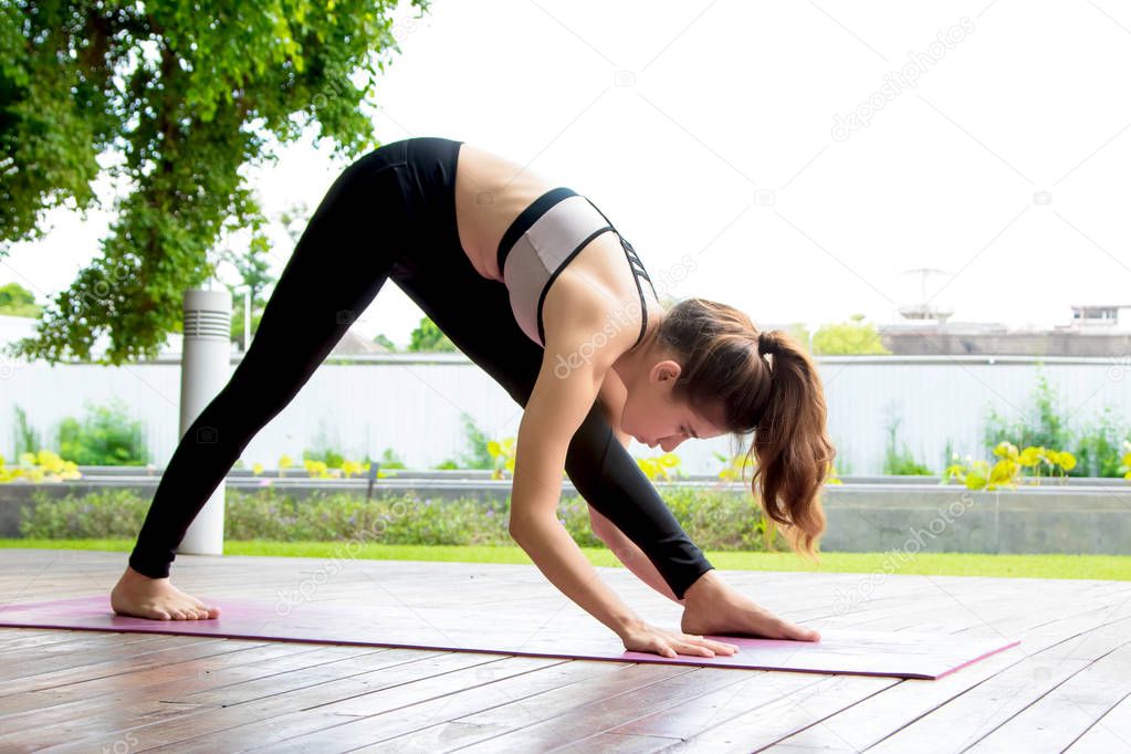 young women doing yoga pose at the park