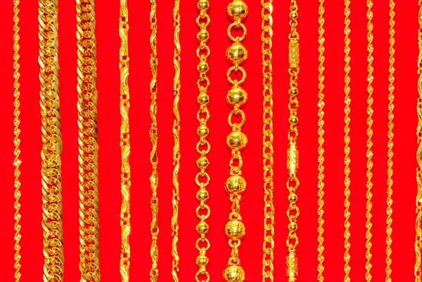 Dentelle de cou d'or, bijoux de chaînes d'or sur fond rouge — Photo