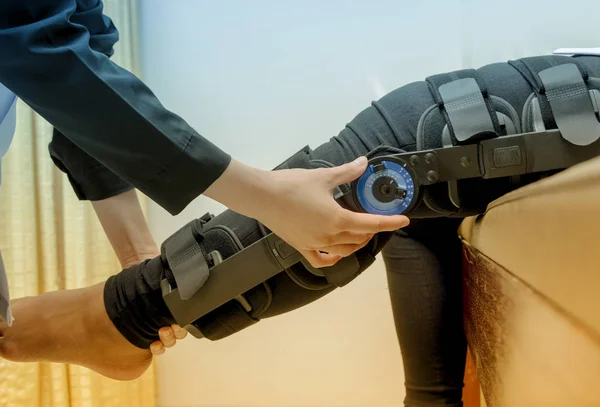 Il fisioterapista aggiusta l "apparecchio per il ginocchio sulla gamba del paziente, Rehabilitat — Foto Stock