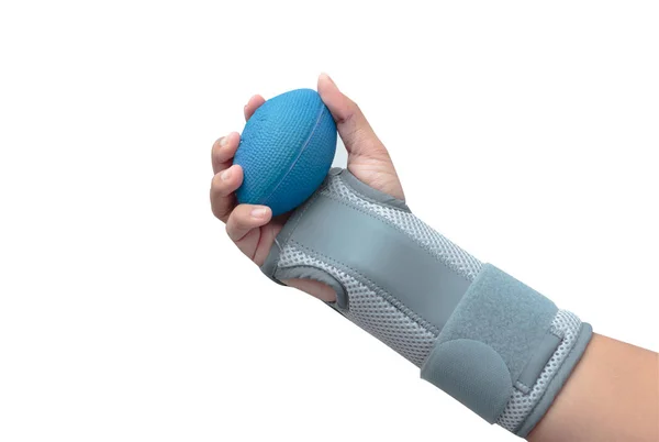 La mano de la mujer con el apoyo de la muñeca apretando una bola suave para el ejercicio de la mano, mano de rehabilitación — Foto de Stock