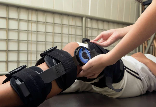 Physiotherapist do stretch exercises on patient's leg, rehabilitation for knee injury — Stock Photo, Image