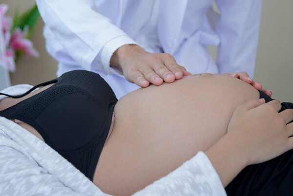 Доктор щупать живот беременной женщины для обследования
