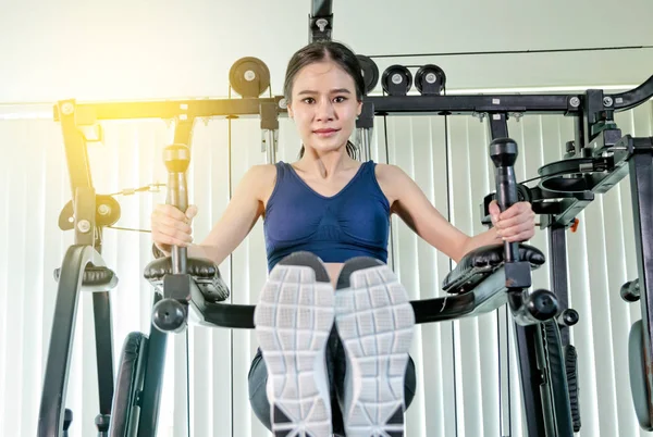 Mulher fitness fazendo exercício com máquina de exercício no ginásio — Fotografia de Stock