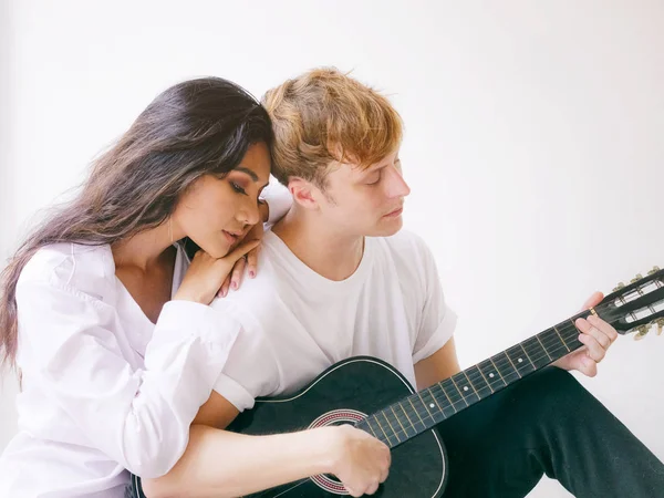 Par i kärlek spelar akustisk gitarr i hemmet — Stockfoto