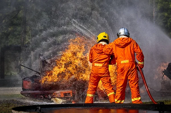 高圧水を噴霧する消防士は 火災に — ストック写真