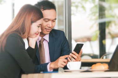 Smartphone kafede çalışan çift iş adamları.