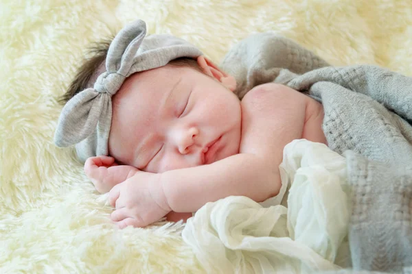 Bebé recién nacido niña está durmiendo en manta de piel —  Fotos de Stock