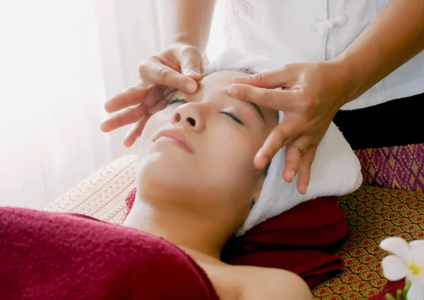 Крупним планом молода жінка отримує спа масаж обличчя в салоні краси . — стокове фото