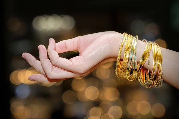 Krásná žena ruka drží zlatý náramek šperky, příslušenství a f — Stock fotografie