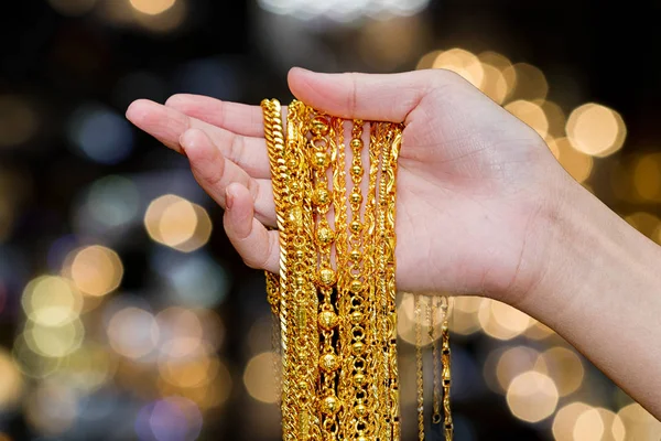Piękna kobieta ręka trzymać złoto naszyjnik biżuteria, akcesoria i f — Zdjęcie stockowe