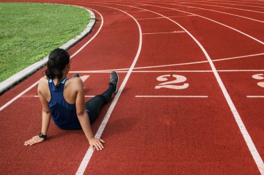 Sonra eğitim ve koşu parkuru üzerinde oturan kadın atlet yorgun