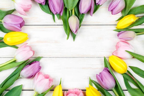 Buquê em forma de coração de tulipas em um fundo de madeira branco — Fotografia de Stock