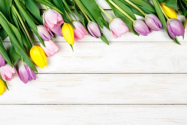 Желтые и розовые тюльпаны на белом деревянном фоне — стоковое фото