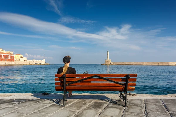 Menina sentada no banco e olhando para o mar . — Fotografia de Stock