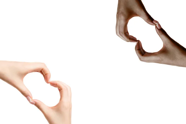 Manos de mujer africana y blanca muestran símbolo de corazón en ba blanca — Foto de Stock