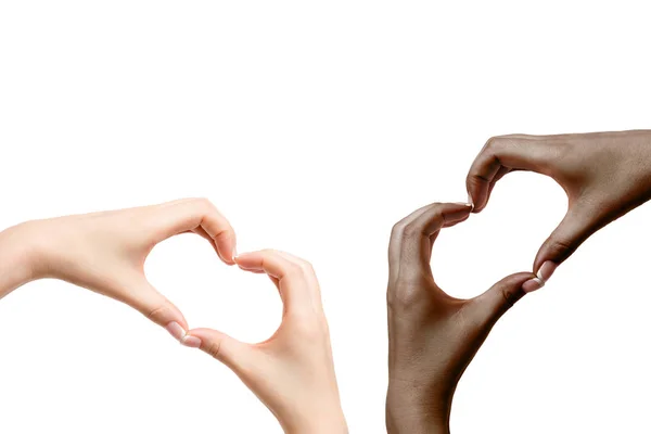 Africanas y blancas manos femeninas muestran el corazón sobre fondo blanco . — Foto de Stock