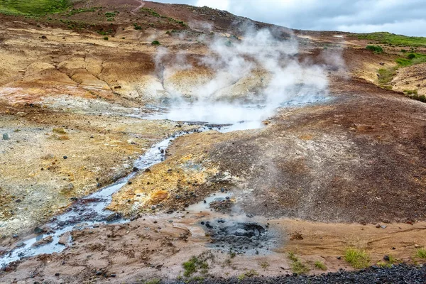 Kochender heißer Frühling in Island vor dem Hintergrund des bunten Gebirges — Stockfoto