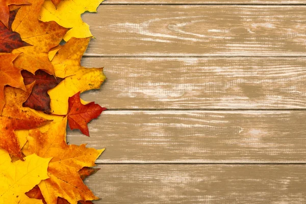 Feuilles d'automne sur le côté gauche du fond brun en bois Photos De Stock Libres De Droits