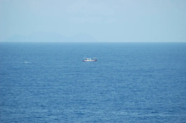 Un pequeño barco de pesca seguido de gaviotas . — Foto de Stock