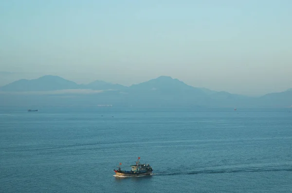 Un barco vietnamita en una bahía rodeada de montañas —  Fotos de Stock