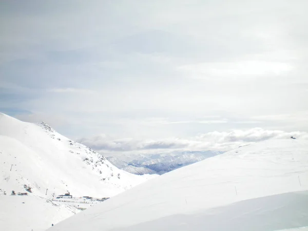 Snötäckta bergen, ovanför en skidort. — Stockfoto