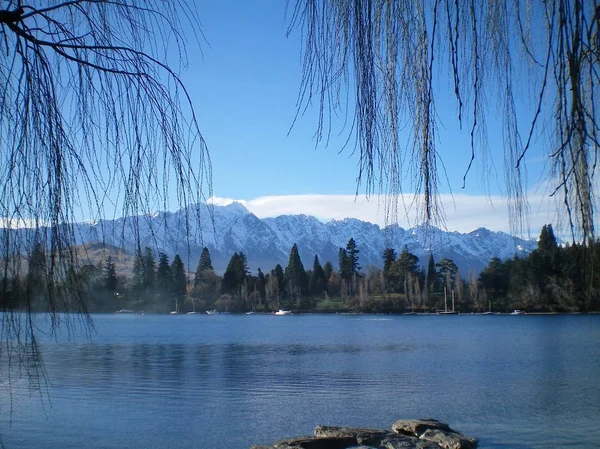 Vista através de um lago para montanhas cobertas de neve . — Fotografia de Stock