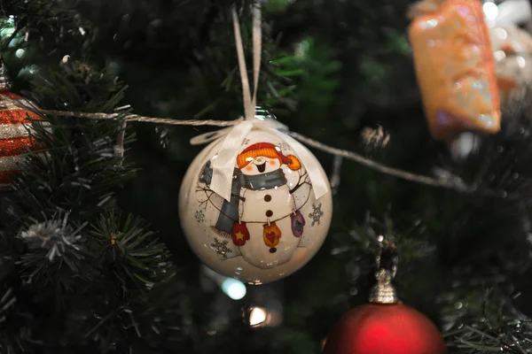 Bola blanca de Navidad con muñeco de nieve colgando en un hermoso Crisma — Foto de Stock