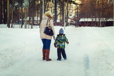 Çocuk ve annesi yürüyüşe çıkıyor.