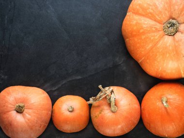 Farklı boyutlarda siyah bir zemin üzerine kabaklar