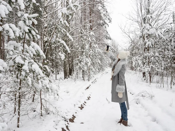 Güzel genç kız selfie bir karlı, soğuk ormanda yapar.