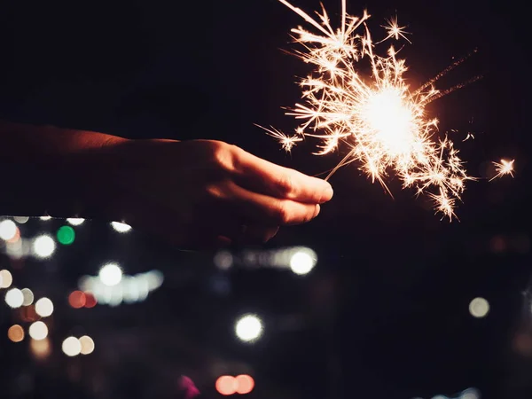 Festive, bright, burning Bengal lights in the mans hand — Stock Photo, Image