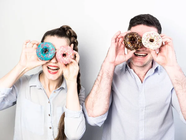 Couple drôle avec beignets colorés — Photo