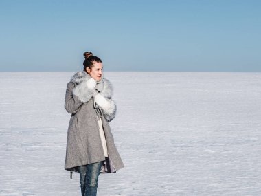 Karlı bir tarlada mutlu bir kadın.