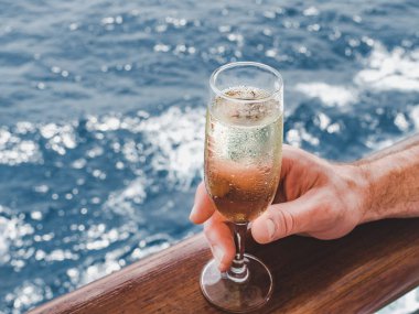 Açık güvertede cam tutan adam.