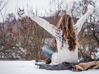 Ağaçların arka planında sevimli bir kadın. Bulutlu, yağmurlu bir gün. Yakın plan, yan görüş. Dinlenme ve rahatlama kavramı