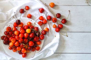 Olgun, sulu kiraz böğürtlenleri ahşap, antika bir masada yatıyor. Üst görünüm, kapat