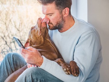 Yakışıklı bir adam ve sevimli bir köpek yavrusu. Yakın plan.