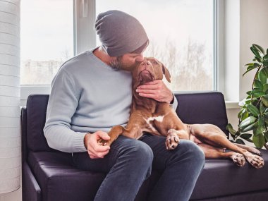 Yakışıklı bir adam ve sevimli bir köpek yavrusu. Yakın plan.