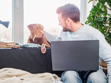 Yakışıklı bir adam ve sevimli bir köpek yavrusu. Yakın plan.
