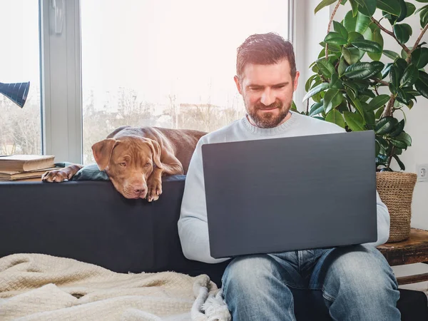 Handsome man and a charming puppy. Close-up — Stock Photo, Image
