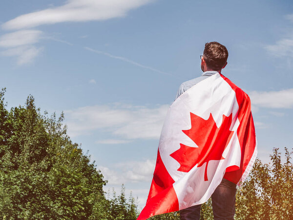 Attractive man holding Canadian Flag. National holiday