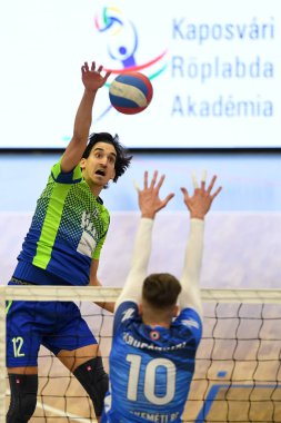 Kaposvar, Macaristan 15 Ocak 2020: Kristof Horvath (yeşil), Kaposvar (mavi) ile Kaposvar, Kaposvar (mavi) arasında oynanan Macaristan Kupası voleybol maçında topa vuruyor..