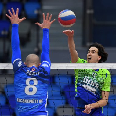 Kaposvar, Macaristan 15 Ocak 2020: Kristof Horvath (yeşil), Kaposvar (mavi) ile Kaposvar, Kaposvar (mavi) arasında oynanan Macaristan Kupası voleybol maçında topa vuruyor..