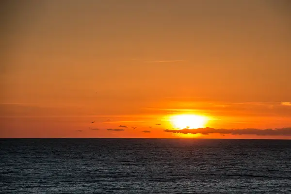 Sonnenuntergang und schwarzes Wasser am dunklen Strand von Spanien — Stockfoto