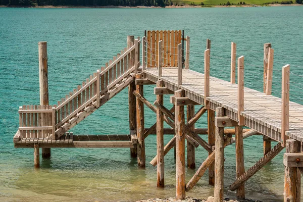 Hnědý dřevěný most nad zelené jezero — Stock fotografie