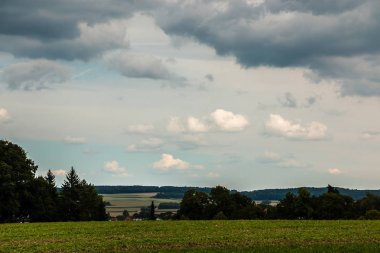 Yeşil alanları, yeşil çayırlar, karanlık ormanlar ve bulutlu gökyüzü