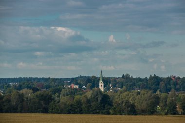 Köy, alanlar, ormanlar ve bulutlu gökyüzü